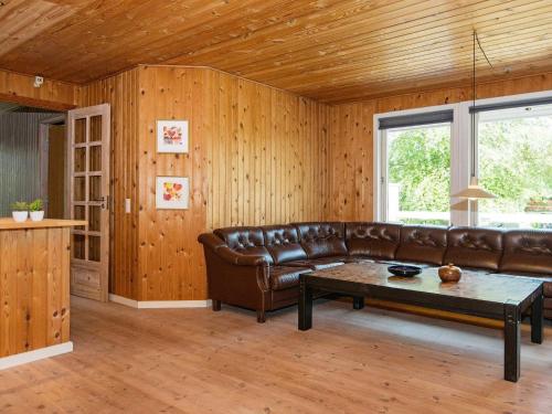 格莱斯堡6 person holiday home in Glesborg的客厅配有真皮沙发和桌子