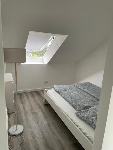 柏林附近贝尔瑙Wohnung im Gästehaus的白色的卧室设有床和窗户