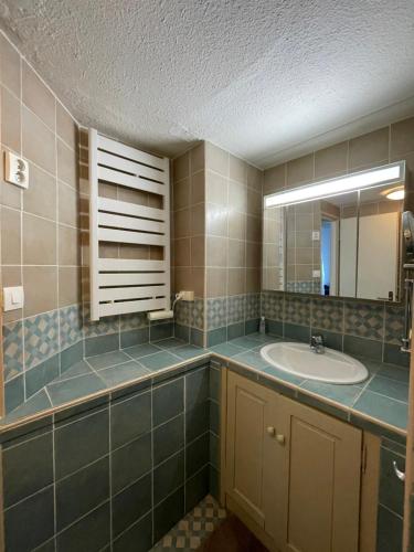 圣马迪拉莫Appartement Duplex Climatisé Le Trident的一间带水槽和镜子的浴室