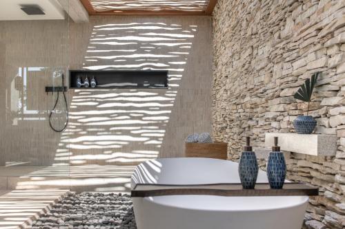 Cap Karoso Sumba - a member of Design Hotels的一间带卫生间和石墙的浴室