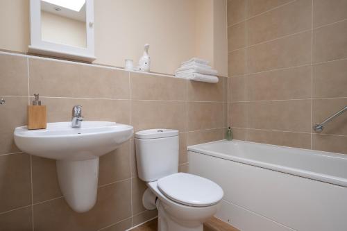 泰特伯里Cosy coach house in historical Tetbury的浴室配有卫生间、盥洗盆和浴缸。