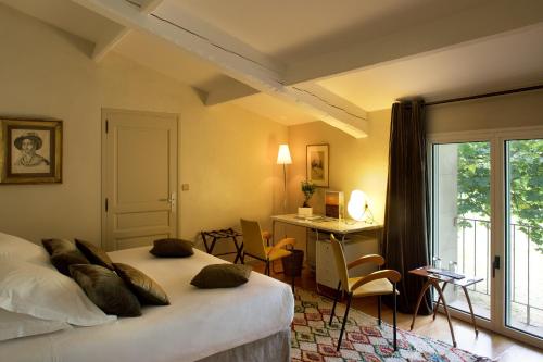 圣雷米普罗旺斯阿尔皮勒城堡酒店的配有一张床、一张书桌和一扇窗户的酒店客房