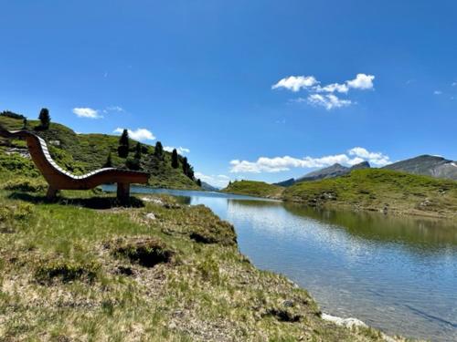 上陶恩Obertauern Fewo Alps -Top 11 by Kamper的坐在水体边的长凳