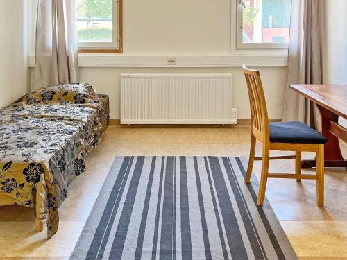 尼奈斯港Holiday home NYNÄSHAMN的一间卧室配有一张床、一把椅子和一张书桌