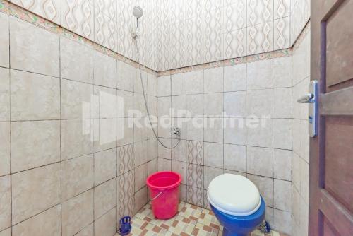 BanjarbaruAna Guest House Syariah Mitra RedDoorz的一间带卫生间和红色桶的浴室