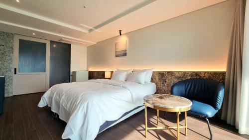 始兴市Hotel GITE的酒店客房,配有床、桌子和椅子