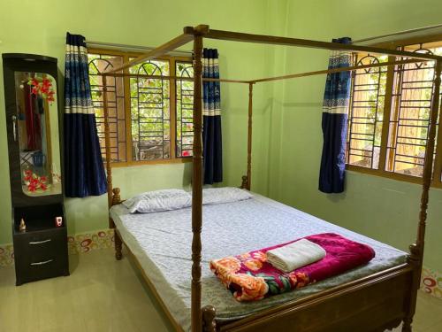 阿加尔塔拉Vamoose S Das Homestay的一间卧室配有一张木床和木架