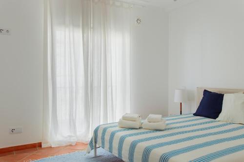 塔维拉Casa do Terreiro的一间卧室配有一张床,上面有两条毛巾