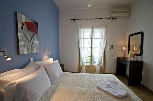 尼欧克利马Violetta Apartments的一间卧室配有一张带白色床单的床和一扇窗户。