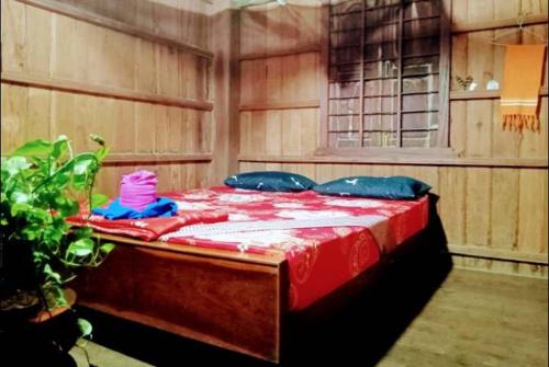 Krong KrachehTonle Mekong Homestay的一间卧室配有红色和蓝色床单