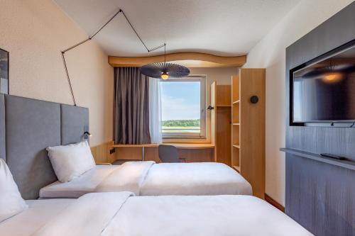 腓特烈港宜必思腓特烈港机场展览馆酒店的酒店客房设有两张床和电视。