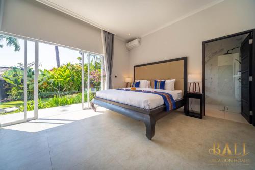 BanjarVilla Akasa Segara Beachfront and Private Pool的一间卧室设有一张床和一个大窗户