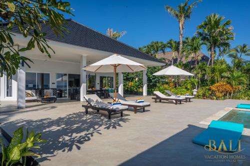BanjarVilla Akasa Segara Beachfront and Private Pool的一个带椅子和遮阳伞的庭院和一个游泳池
