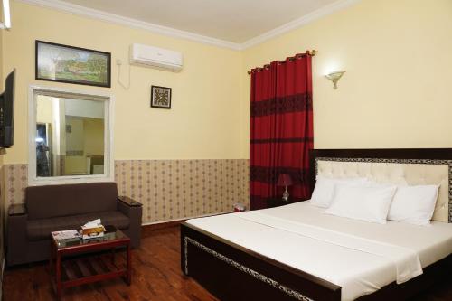 伊斯兰堡ORION INN Guest House F-7 Islamabad的一间卧室,卧室内配有一张床和一把椅子