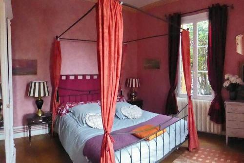 阿卡雄Villa Thomas的一间卧室配有一张带红色窗帘的天蓬床