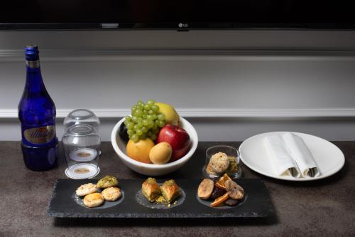 伊斯坦布尔Mula Hotel的盘子上放着一碗水果和一盘食物
