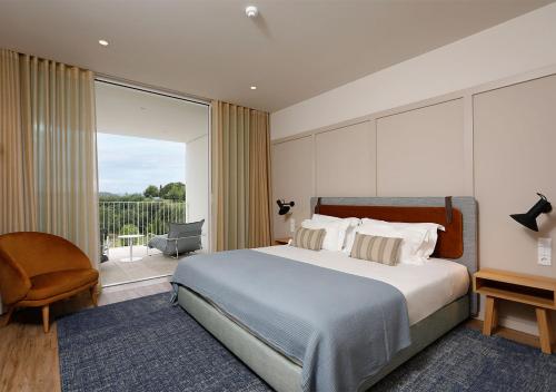 莫尔塔瓜蒙特贝罗阿归拉湖度假温泉酒店 的一间带大床的卧室和一个阳台