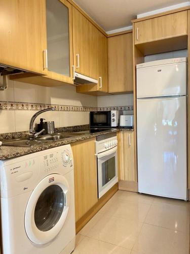 米拉多罗Andainas Apartamentos Turísticos A的厨房配有洗衣机和白色洗碗机