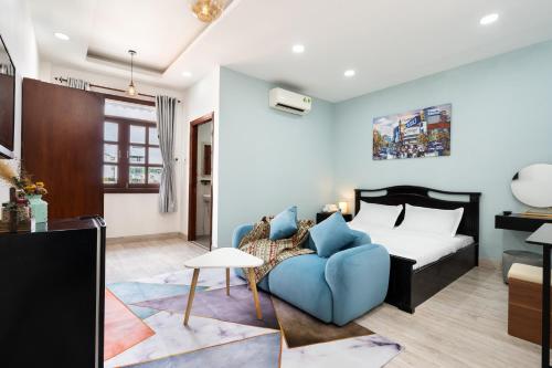 胡志明市The Lovenote Home的一间卧室配有一张床和一张蓝色的沙发