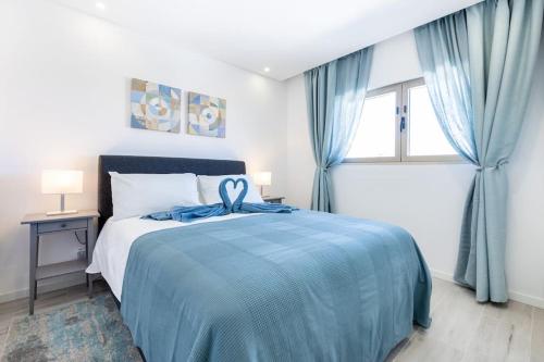 布尔高The Hub central apartment Burgau的一间卧室配有一张带蓝色毯子的床和窗户。