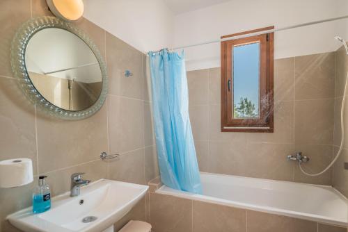 吉奥塔略Ciel Blue Villas的一间带水槽、浴缸和镜子的浴室