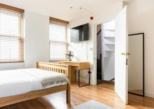 伦敦Modern Studio Apartment In Shoreditch的一间卧室配有一张床和一张书桌