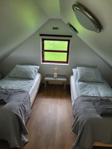 塞尔福斯Hólar Countryside Cabin 2的阁楼卧室设有两张床和窗户。
