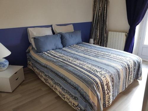 雷穆兰Maison au Pied du Pont du Gard的一间卧室配有一张蓝色床头板的床