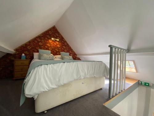 RoughtonBarnacle Barn, North Norfolk的阁楼上的卧室配有一张大床