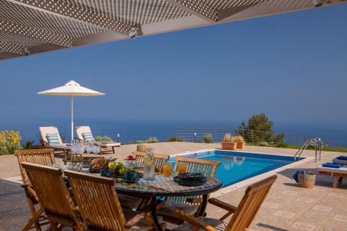 卡拉米锡Avraam Sunset Villas with Private Heated Pools by Imagine Lefkada的游泳池旁带桌椅的天井