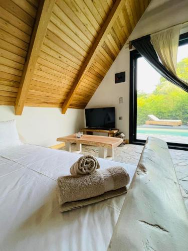 奥林匹亚达Unique wooden villa with pool的卧室配有白色的床和大窗户