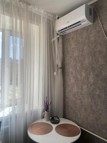 库斯塔奈Комфортабельные - Уютные апартаменты в Костанай Алтын Арман的一间设有白色桌子和窗户的客房