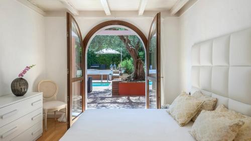 米萨诺阿德里亚蒂科VILLA ROSSA 12, Emma Villas的一间卧室设有一张床和一个拱门