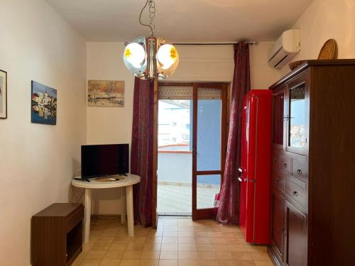 斯卡莱阿Appartamento Gabbiano的一间设有红色冰箱和电脑桌的房间