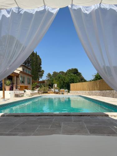 拉莫特Les jardins de Manotte的游泳池上方设有白色窗帘