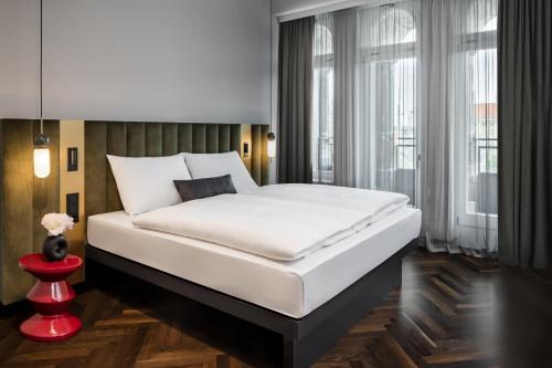 莱比锡AMANO Home Leipzig的卧室设有一张白色大床和一扇窗户。
