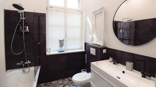 萨勒河畔哈雷Grâce Boutique Apartments的带浴缸、卫生间和镜子的浴室