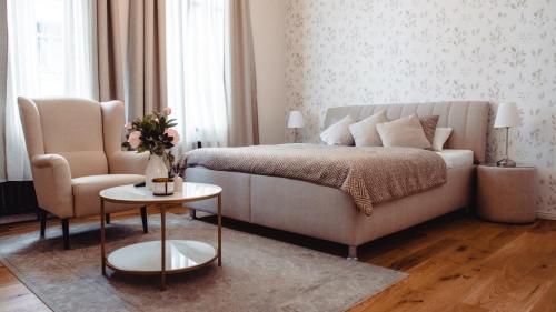 萨勒河畔哈雷Grâce Boutique Apartments的一间卧室配有一张床、一张沙发和一把椅子
