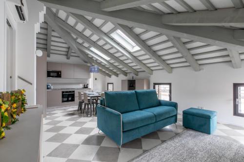 奇塔代拉Corte alle mura - Mansarda lux的一间带蓝色沙发的客厅和一间厨房