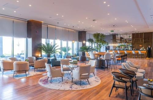 撒马尔罕Wellness Park Hotel Bactria的酒店大堂设有桌椅和酒吧