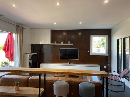 滨海阿热莱斯CASA LUIS - Bel appartement avec piscine et proche de la mer的客厅配有桌子和电视