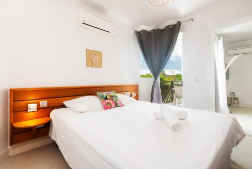 圣弗朗索瓦Tropical Cocooning的一间卧室设有两张白色的床和窗户