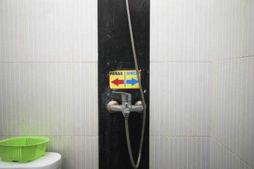 梭罗Capital O 2258 Santana Syariah Guest House的一间带卫生间的浴室和墙上的标志