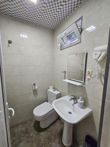 马钦加里Junona的浴室配有白色卫生间和盥洗盆。