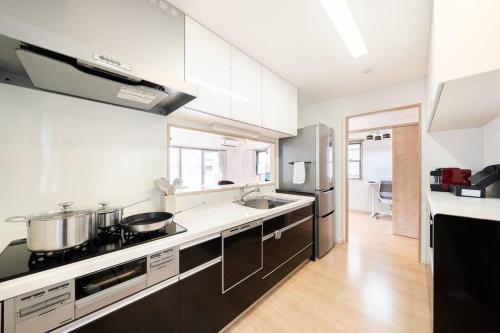 东京Generous Forest 301的一间厨房,配有白色的墙壁和黑色的家电