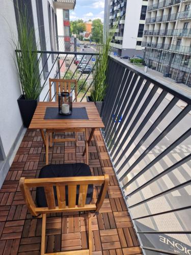 维尔纽斯Aurea apartment的阳台配有木桌和两把椅子