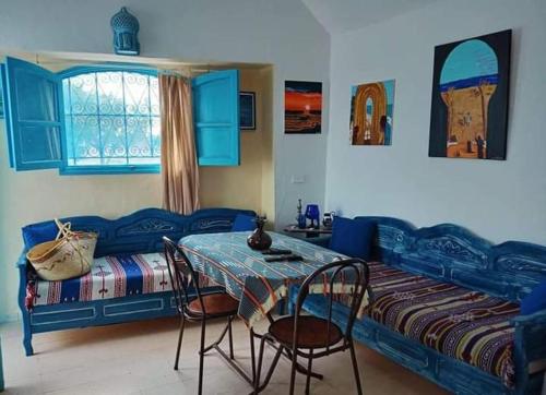 米多恩Bungalow de charme的卧室配有一张床和一张桌子及椅子