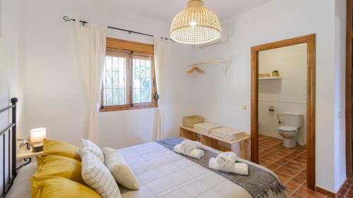 BorgeCasa Los Limones El Borge by Ruralidays的一间卧室配有一张床、一个卫生间和一面镜子