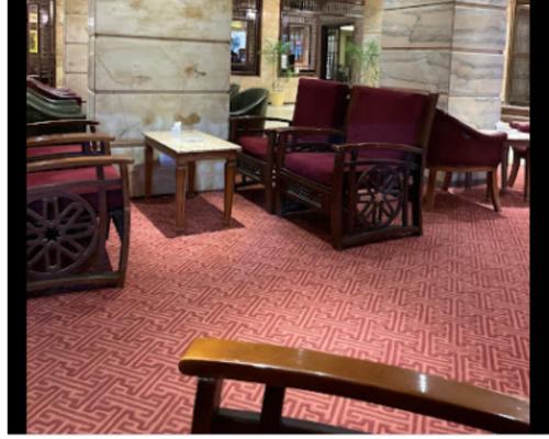 曼苏拉Salvatore Rooms With Breakfast -Train Station的一间铺有红地毯并配有桌椅的房间