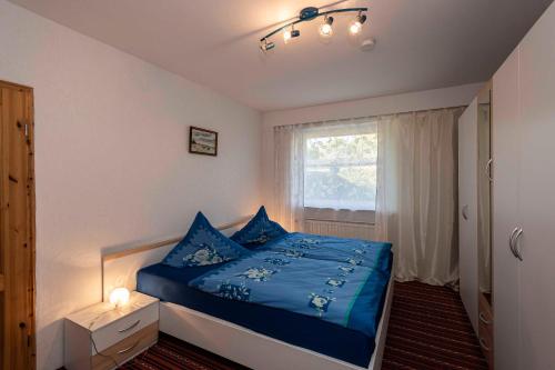 萨斯尼茨Ferienwohnung Wenzlaff的一间卧室设有蓝色的床和窗户。